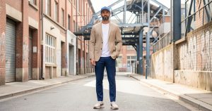 Homme portant une tenue urbaine sobre avec casquette et baskets polyvalentes.
